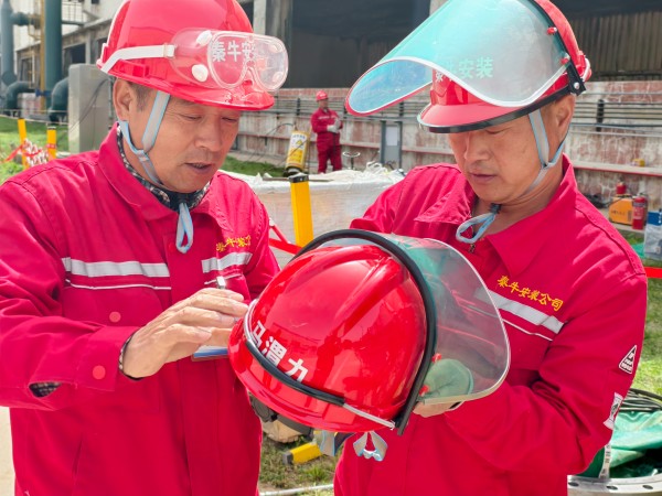 团结协作 施工人员正在为其工友安装安全面罩.jpg